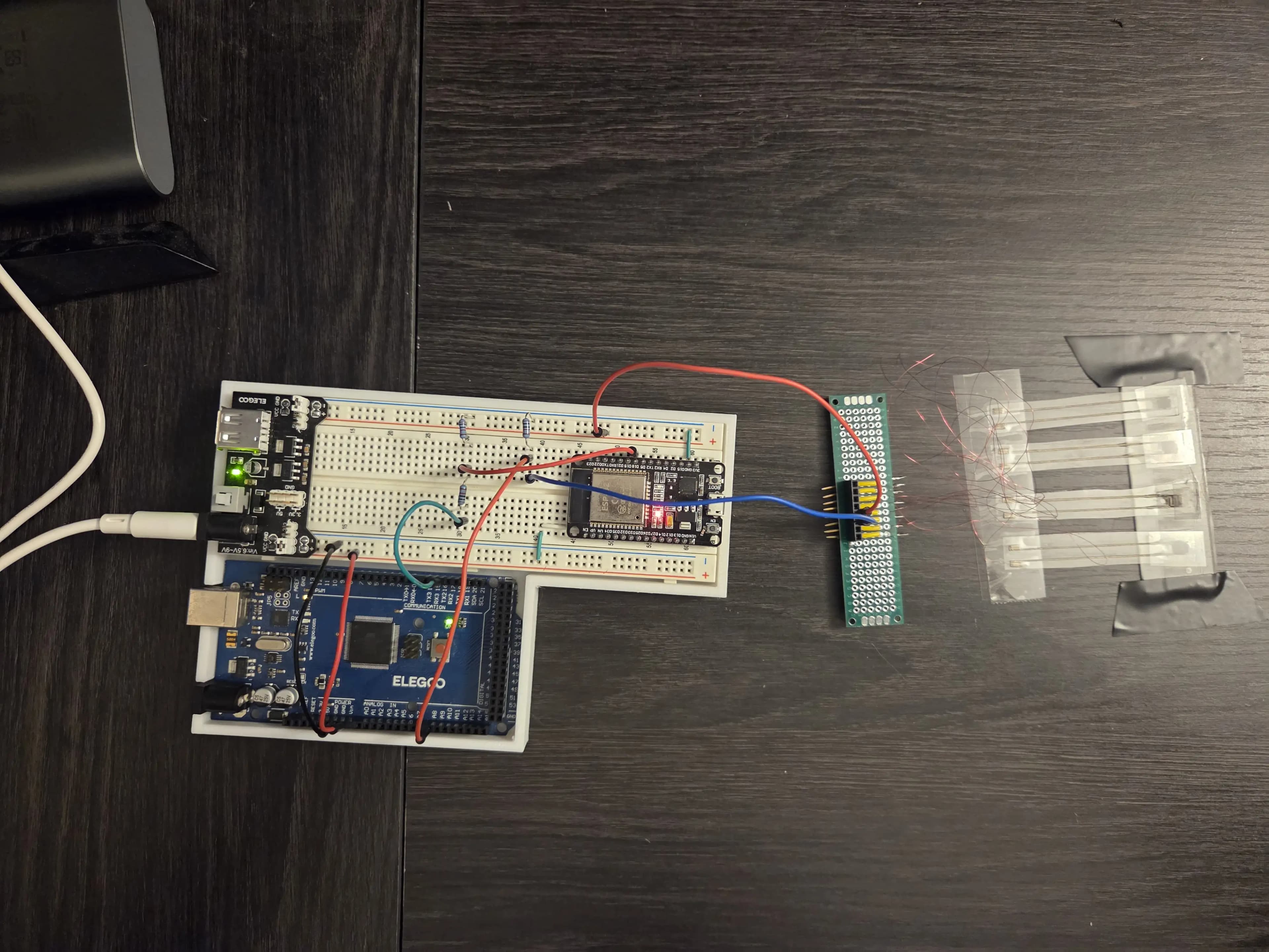 Picture of electronics with breadboard, Arduino, ESP32, and force-sensitive resistors.